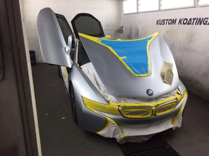 Silver BMW i8 in a paint booth masked with tape and film for automotive coating and refinishing