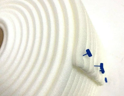 Close-up of white premium foam masking tape roll with blue push pins in a bright setting